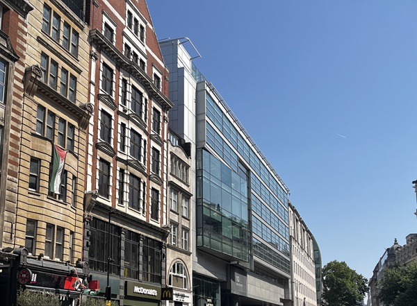 Glass-fronted contemporary building between period brick façades
