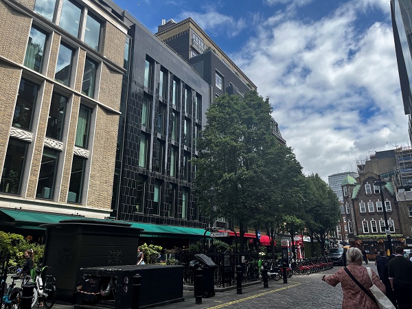 Contemporary tiled building above street-level restaurants, Soho.